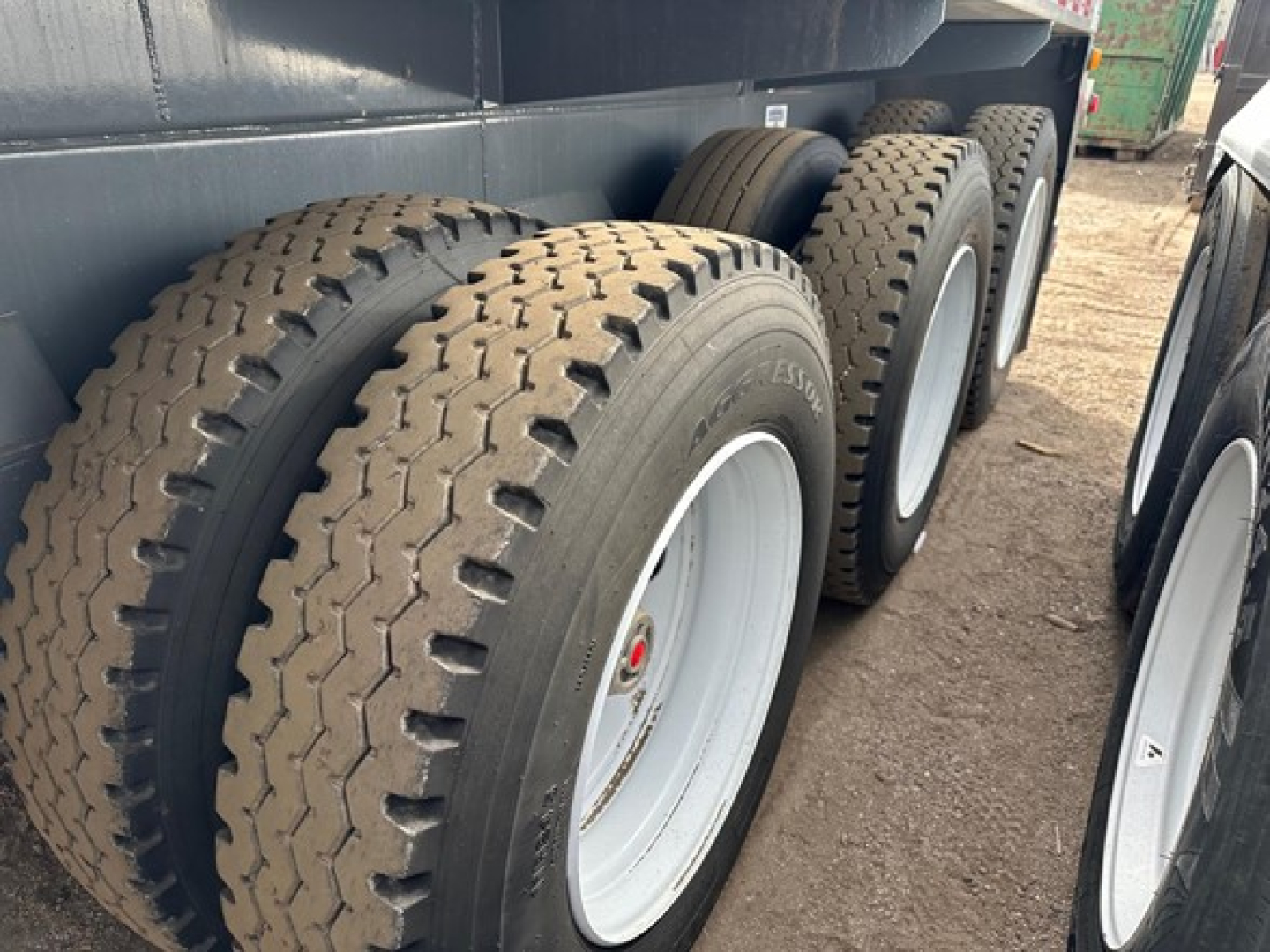 Trailer wheel set showing multiple dual tires on a Dragon Non-Code Vac Tanker trailer, with visible tire treads and white rims.