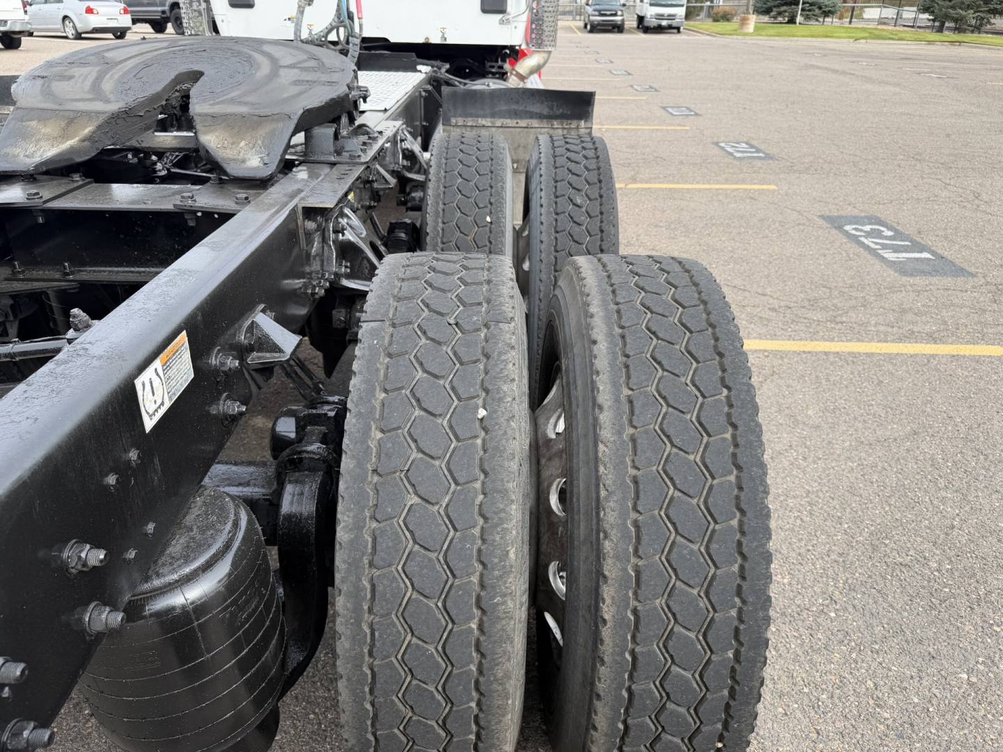Kenworth T880 chassis with dual rear axles and tires, side view showing wheel arrangement and chassis frame.