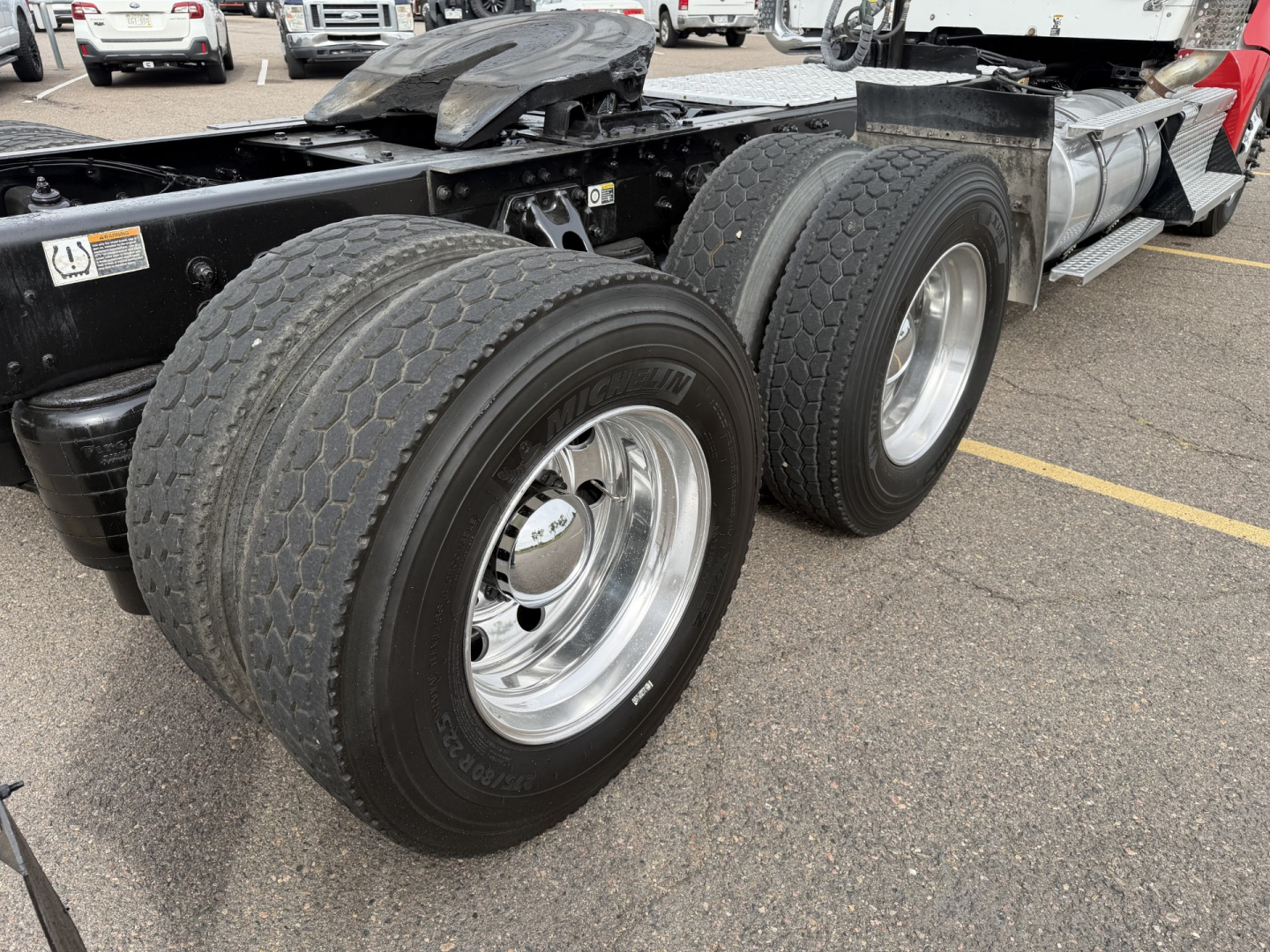 Kenworth T880 rear wheels and chassis showing dual rear axles with chrome rims and heavy-duty tires.