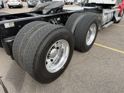 Kenworth T880 rear wheels and chassis showing dual rear axles with chrome rims and heavy-duty tires.