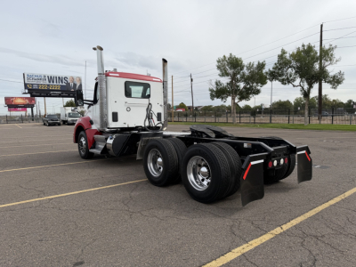 Kenworth T880 tractor rear and chassis view showing dual rear axles and mud flaps.