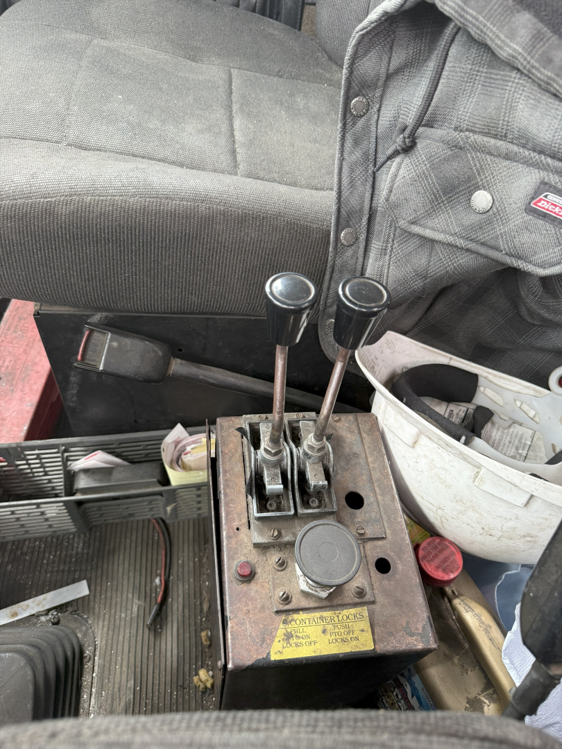 Kenworth T800 cab interior with joystick-style levers and control box showing two gear levers and a yellow label