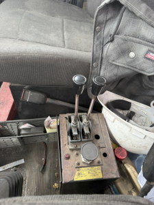 Kenworth T800 cab interior with joystick-style levers and control box showing two gear levers and a yellow label