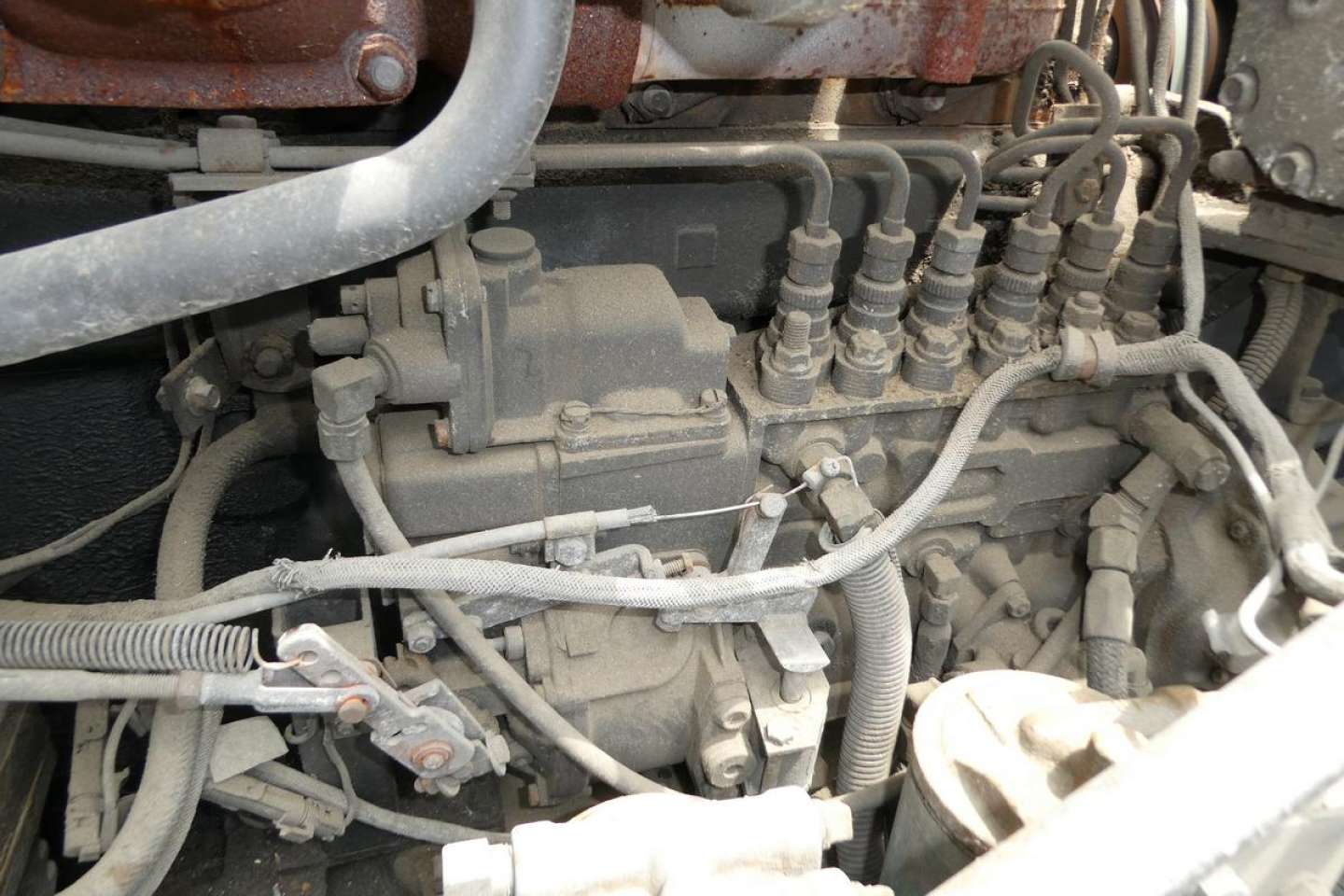 Mack RD690S engine bay showing hydraulic lines and fuel injector system components.