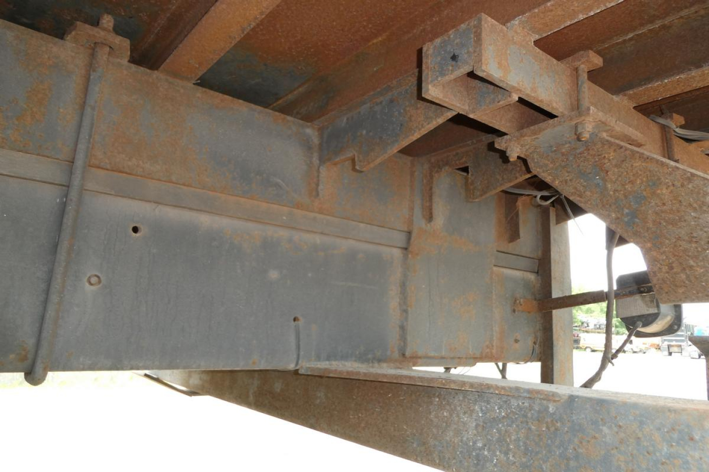 Structural undercarriage of a Mack RD690S flatbed showing rust-free metal frame and hitch components.