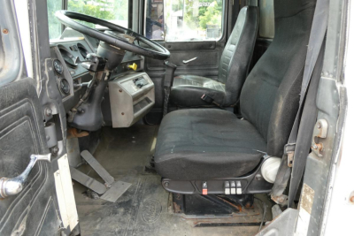 Mack RD690S truck cabin interior showing driver seat and dashboard with worn floor mat and steering wheel.