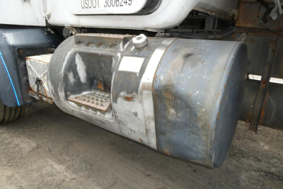 Mack RD690S truck fuel tank and undercarriage view showing cylindrical metal fuel tank and steps.