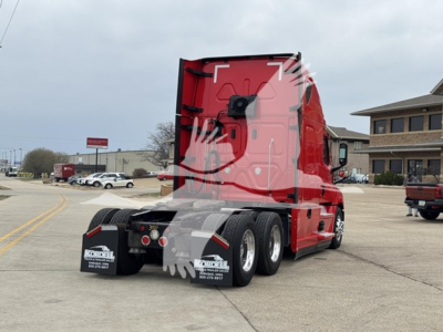 Freightliner Cascadia 126 sleeper tractor rear view showing red cab, dual rear axles, and mudflaps with dealer stickers.