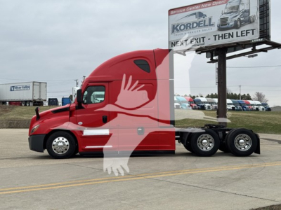 2023 Freightliner Cascadia 126 sleeper tractor in red, side view with trailer, visible billboards in background.
