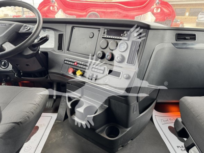 Cabin dashboard of Freightliner Cascadia 126 truck showing steering wheel, center console, vents, and control knobs.