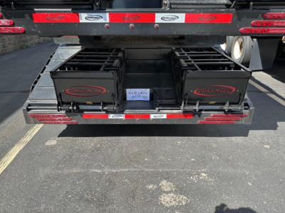 Dura Haul steel drop deck trailer rear view with beavertail and two tool boxes labeled DURA-HAUL.