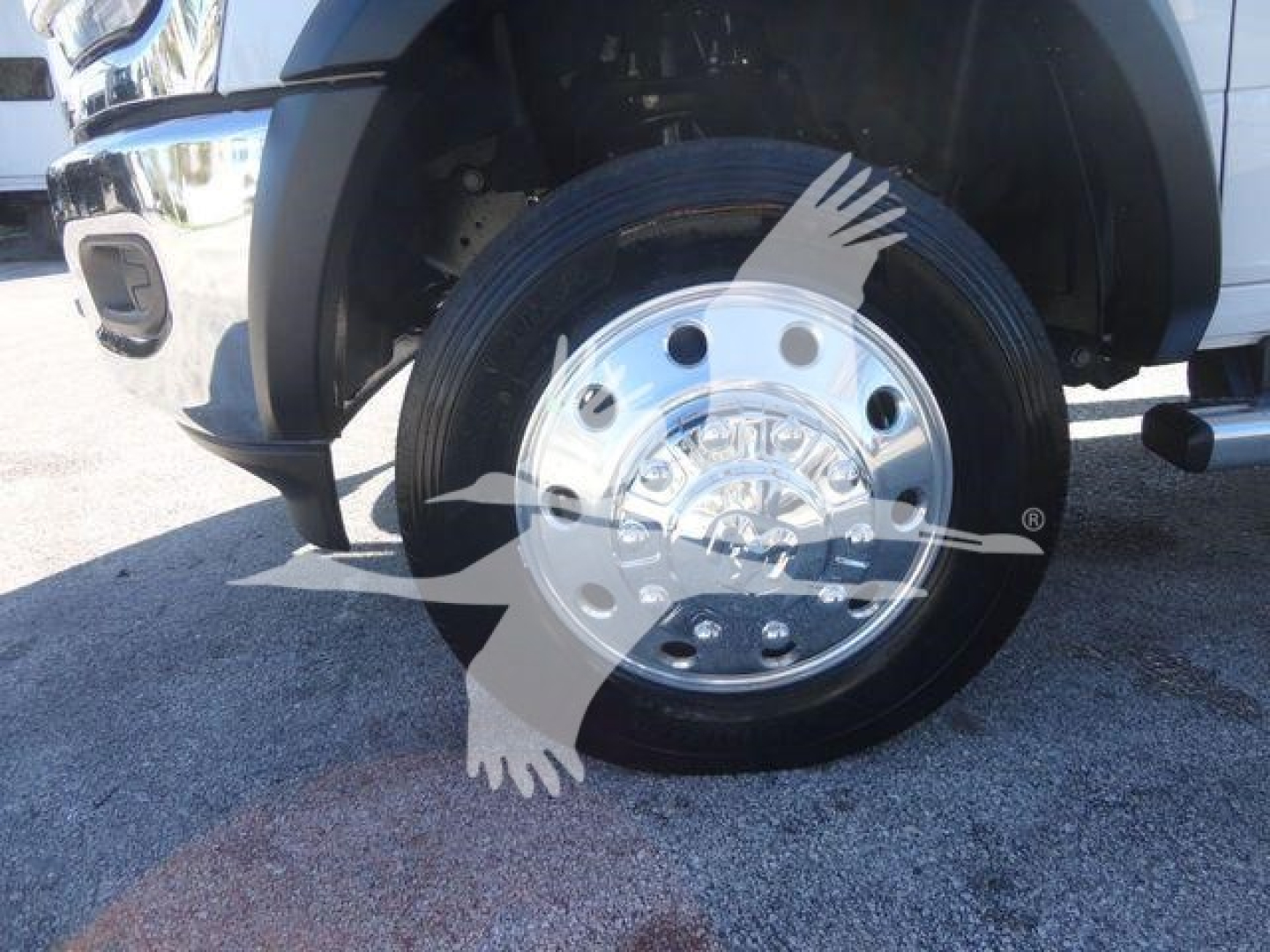 Ram 4500 wheel and tire close-up showing polished steel hub, black tire, and partial wheel well; front-left of a pickup truck with chrome bumper