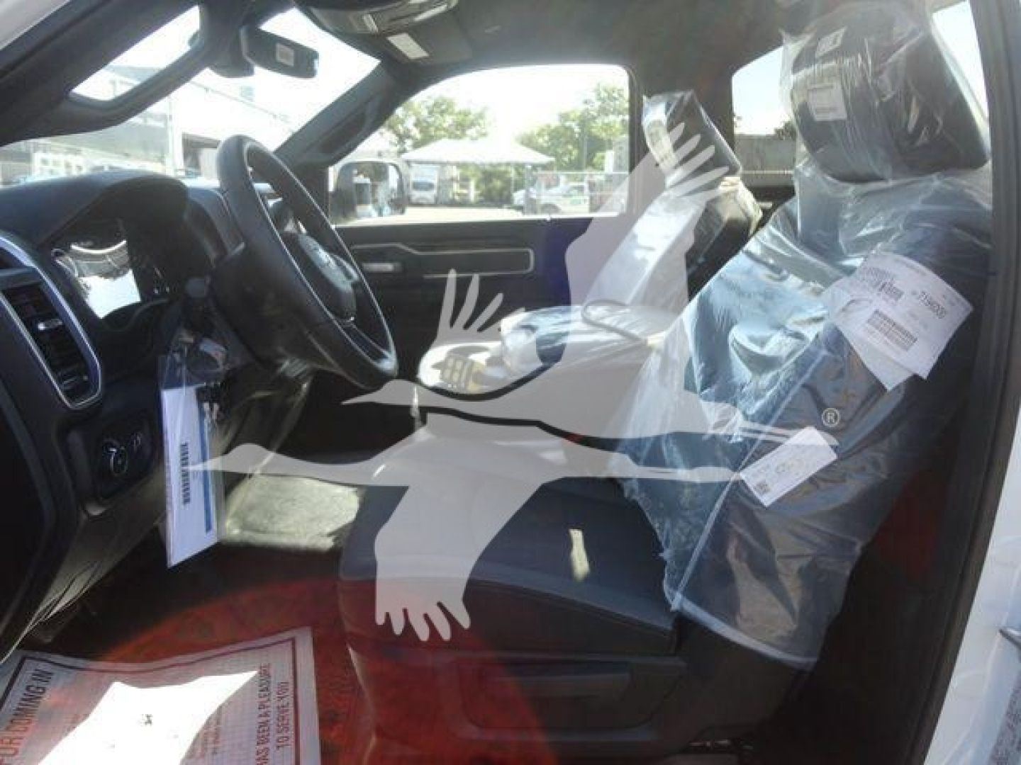 Truck interior showing front seats and steering wheel in a Ram 4500 SLT, with protective plastic on seats.