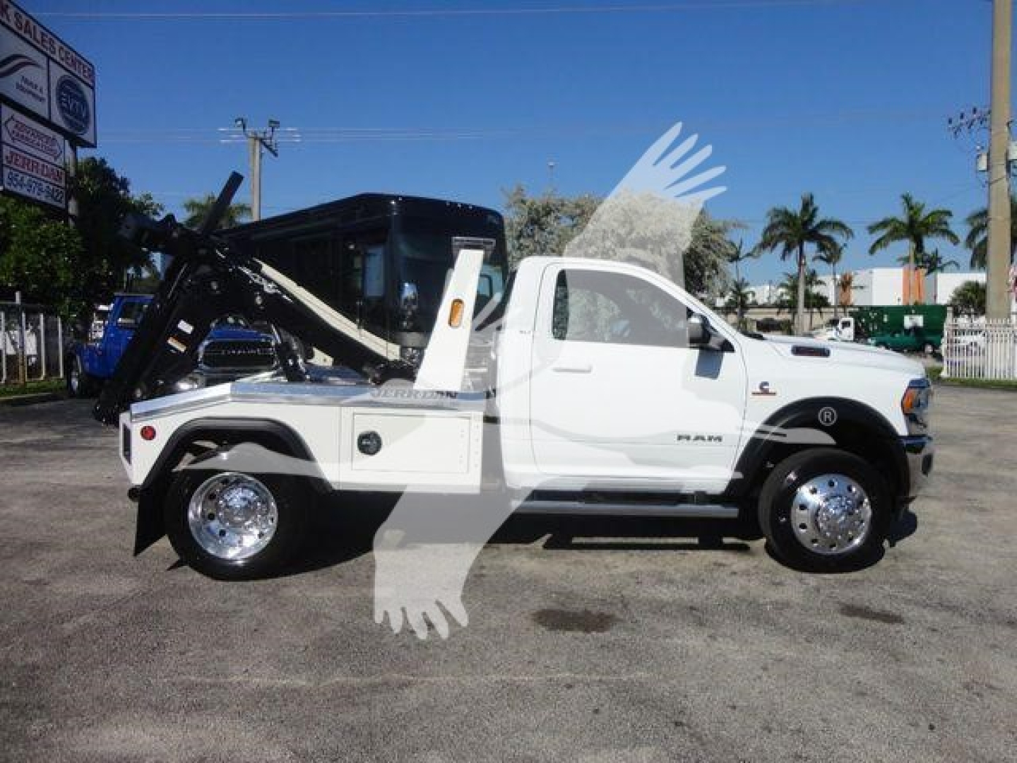 2014-2024 Ram 4500 SLT tow truck with bed loader and winch, white cab, black crane arm, wheel covers, visible side text 'RAM 4500' on front door.