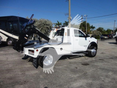 Ram 4500 SLT tow truck with hydraulic bed and winch, side view showing white cab and black equipment, stock number J74215