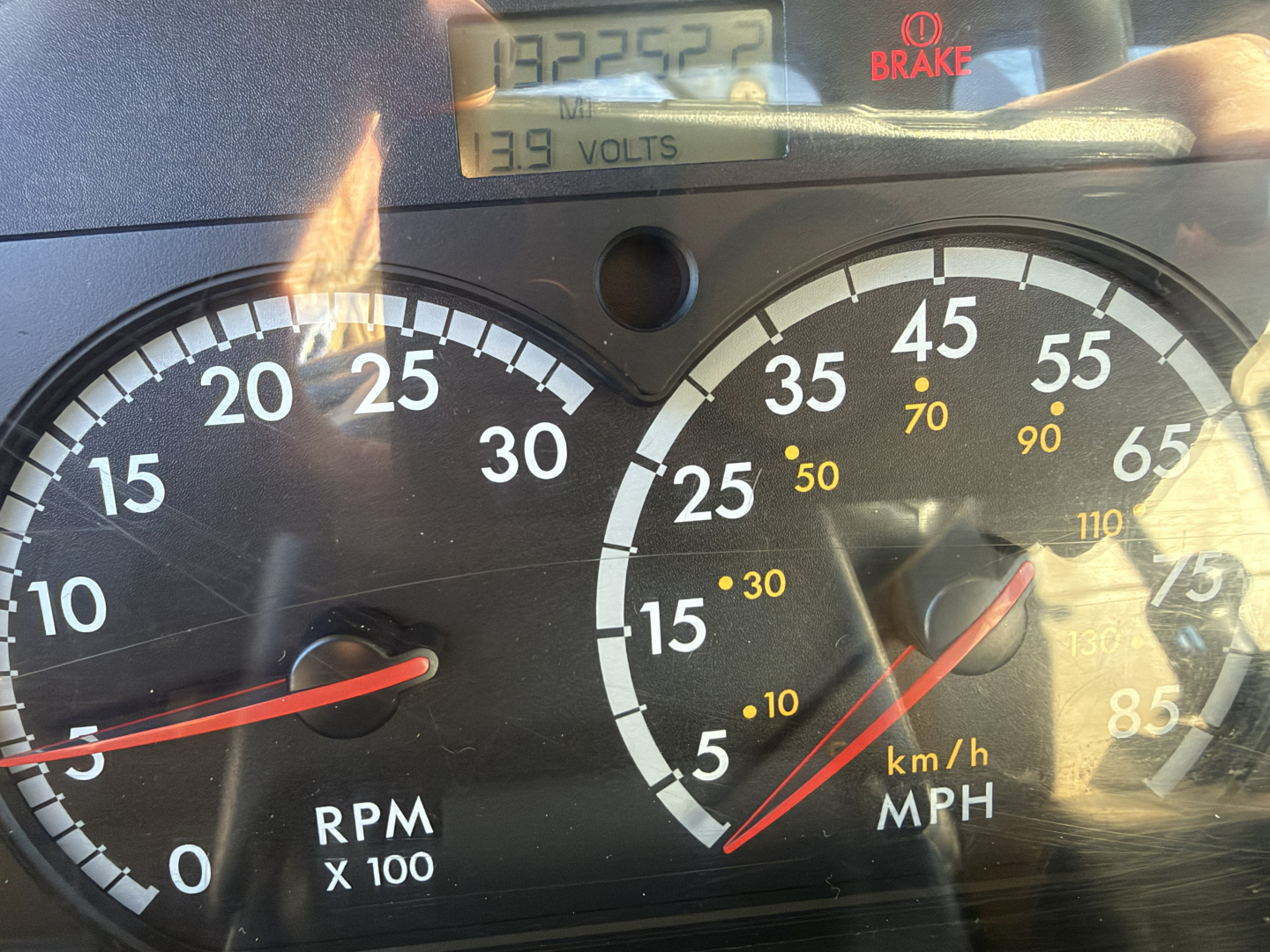 Dashboard and gauges of a 2006 Sterling LT9500 boom truck showing RPM gauge, speedometer, and a digital readout with 139 volts and 139 volts? The image includes a tachometer labeled RPM x100 and a speedometer in km/h and mph with a red need