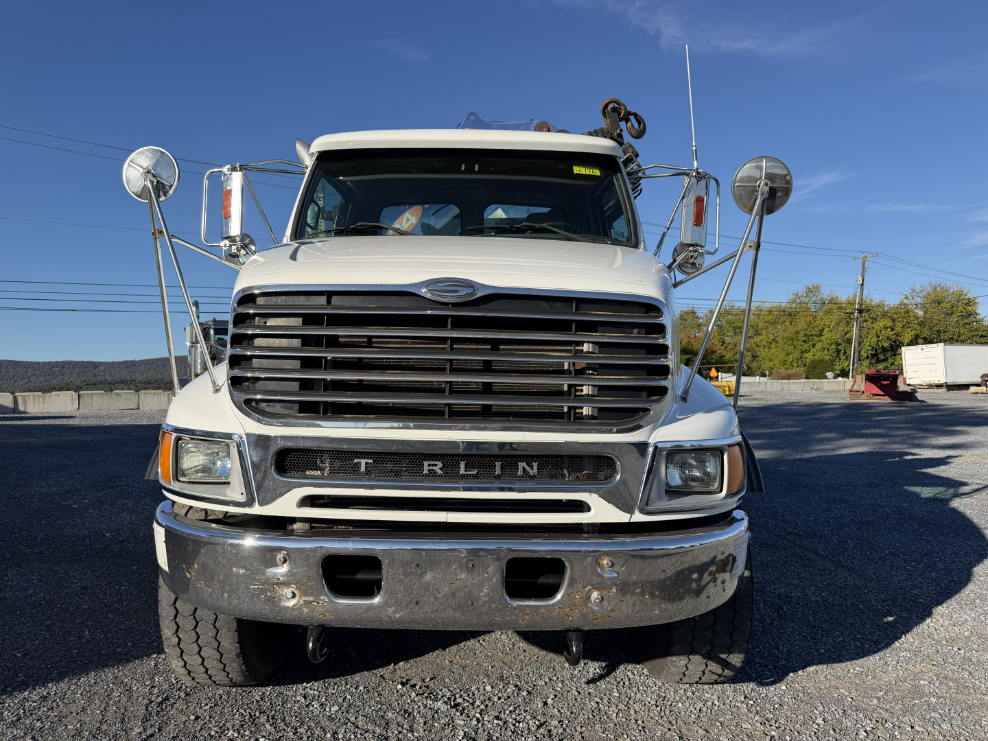 Front view of a white 2006 Sterling LT9500 boom truck showing large grille and bumper.