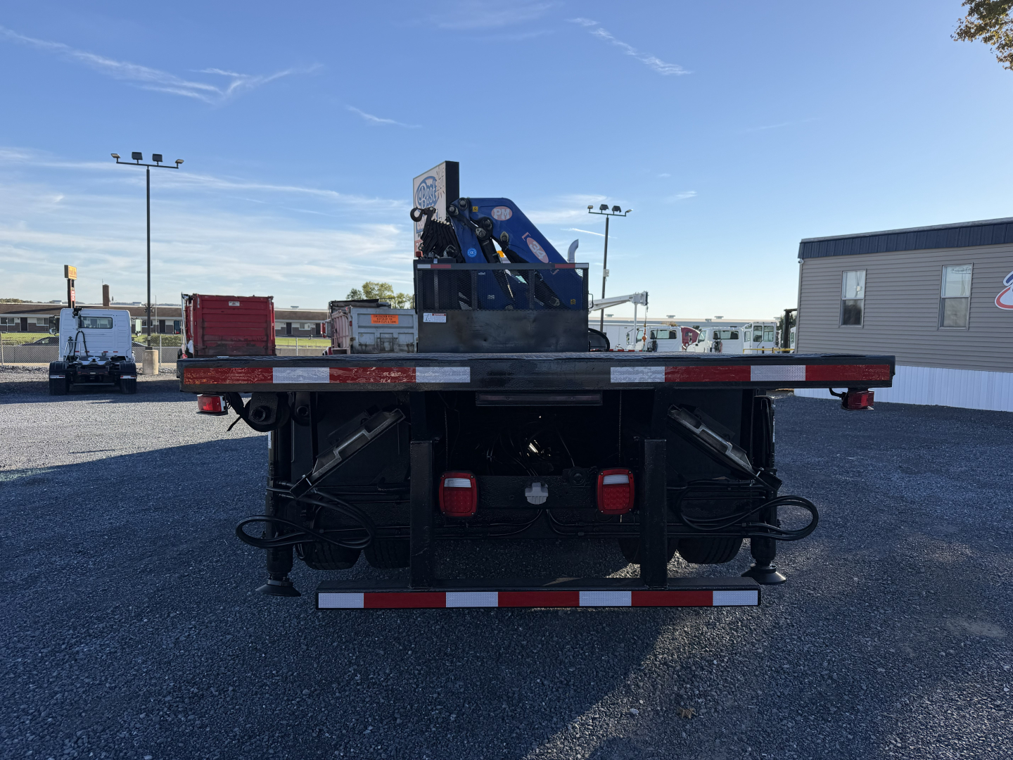 Back view of 2006 Sterling LT9500 boom truck showing rear platform and stabilizers with hydraulic lines and taillights.