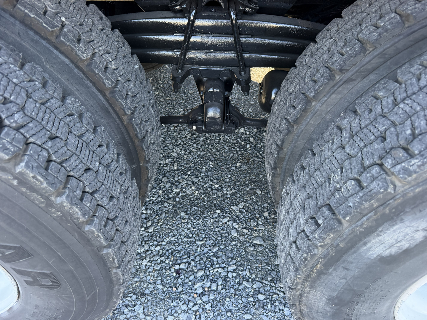 ISO twin rear-wheel area of a Sterling LT9500 truck showing dual rear tires, suspension linkage, and drive shaft components visible between the wheels.