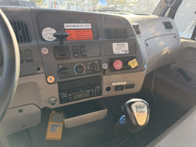 Truck cab dashboard and steering wheel of a 2006 Sterling LT9500 boom truck interior with gear shifter labeled Eaton Fuller.