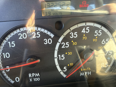 Dashboard and gauges of a 2006 Sterling LT9500 boom truck showing RPM gauge, speedometer, and a digital readout with 139 volts and 139 volts? The image includes a tachometer labeled RPM x100 and a speedometer in km/h and mph with a red need