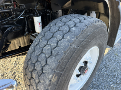 Front wheel and suspension view of a 2006 Sterling LT9500 truck showing tire tread, wheel hub, and partial engine bay components.