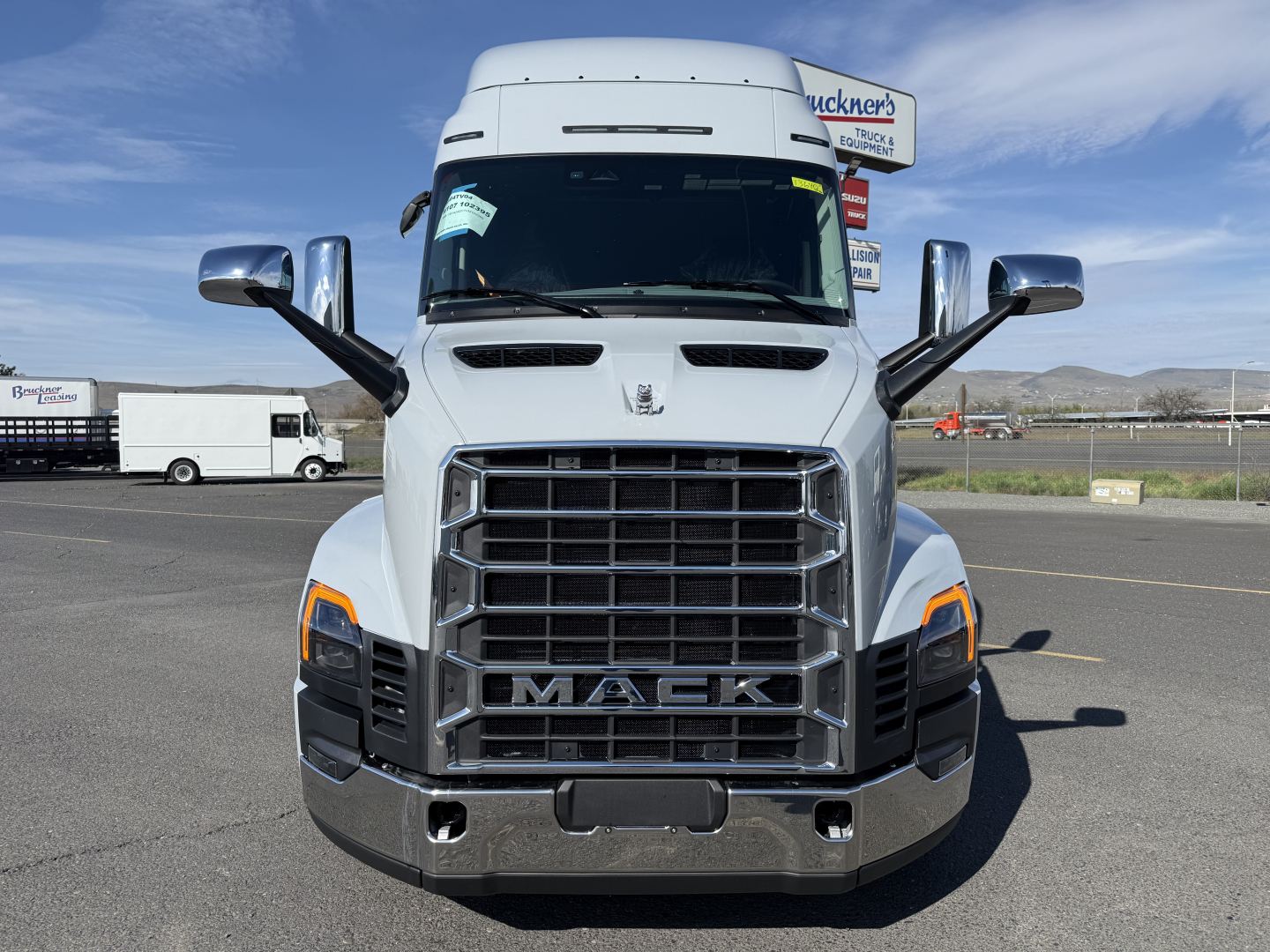 Front view of a white 2027 Mack AN64T64 conventional sleeper truck with large grille, hood vents, and chrome mirrors.