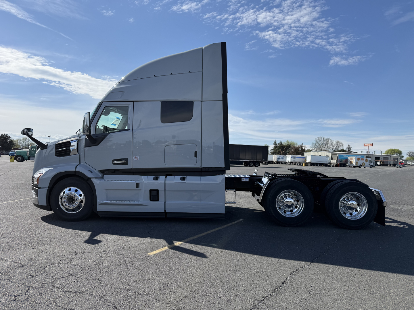 Side view of a Mack AN64T64 tractor with sleeper cab, showing aluminum wheels and dual rear axles.