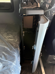 Cab interior showing open center console and storage cabinet inside a Mack AN64T64 truck cab.