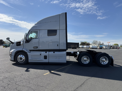 Side view of a Mack AN64T64 tractor with sleeper cab, showing aluminum wheels and dual rear axles.