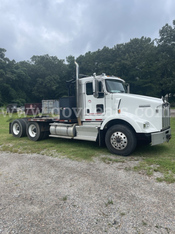 Kenworth T800 truck cab and flatbed chassis side view in white with dual rear axles.