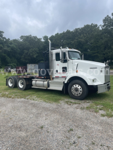 Kenworth T800 truck cab and flatbed chassis side view in white with dual rear axles.