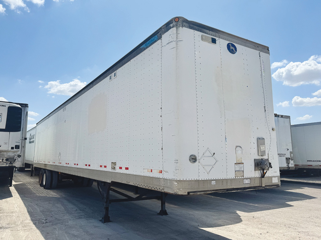 Great Dane aluminum trailer in a yard showing side and rear with landing gear down, white exterior, and rear doors.