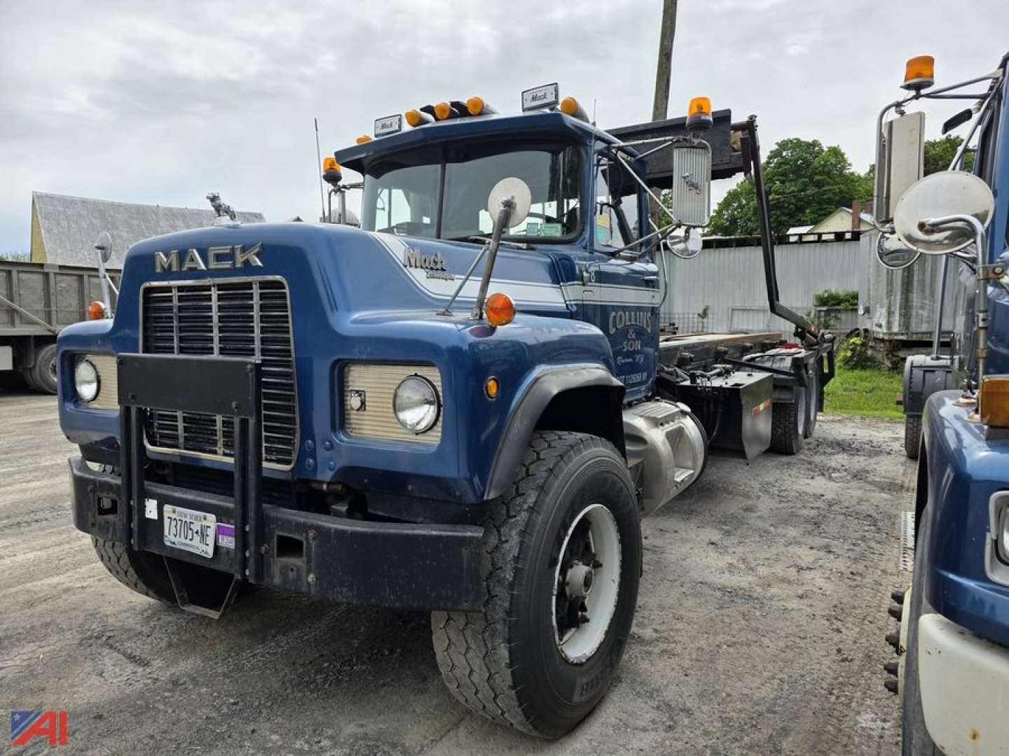 Mack RD688S roll-off truck in blue showing cab, front grille, dual headlights, and side mirrors.