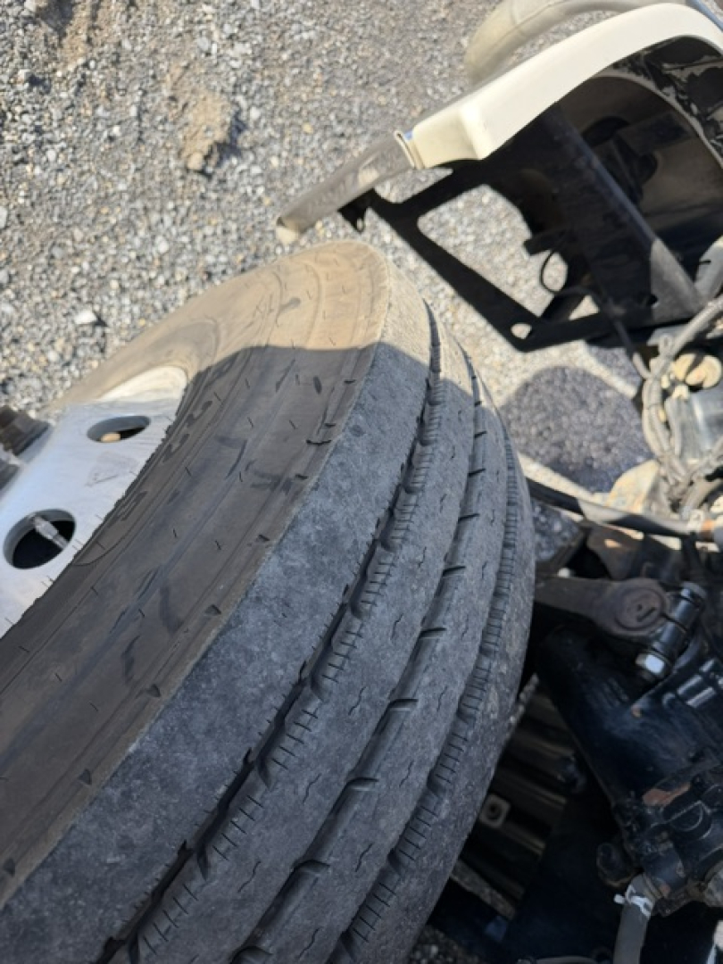 Truck wheel and undercarriage in view showing tire tread and suspension components
