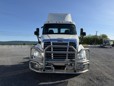 Freightliner Cascadia daycab truck front view with chrome grille guard and bumper; windshield, headlights, and mirrors visible.