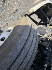 Truck wheel and undercarriage in view showing tire tread and suspension components