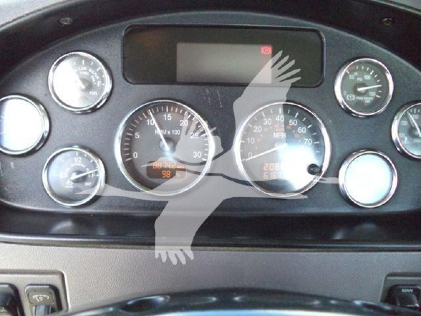Peterbilt 337 dashboard showing tachometer and speedometer gauges with digital display and various dials.