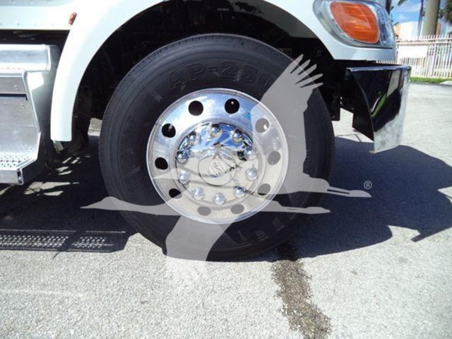 Front left wheel of a 2020 Peterbilt 337 rollback truck showing wheel and tire with chrome hubcap and fender; faint watermark overlay.
