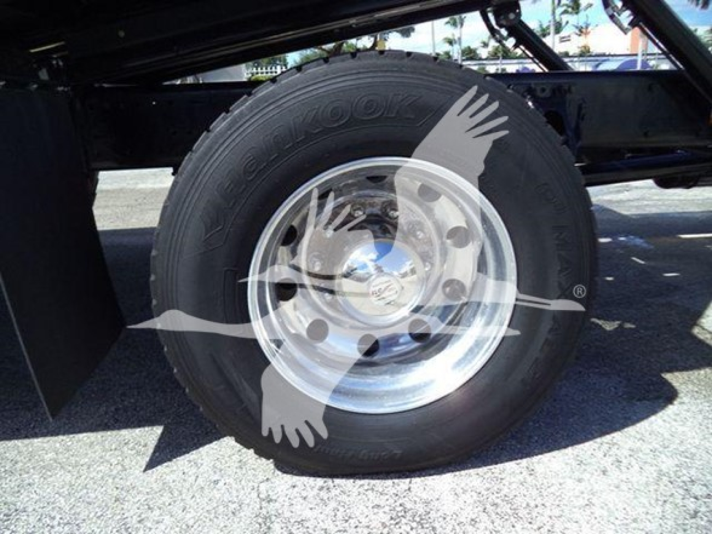 Truck rear wheel with Goodyear tire and polished steel rim on Peterbilt 337 rollback frame, visible undercarriage.