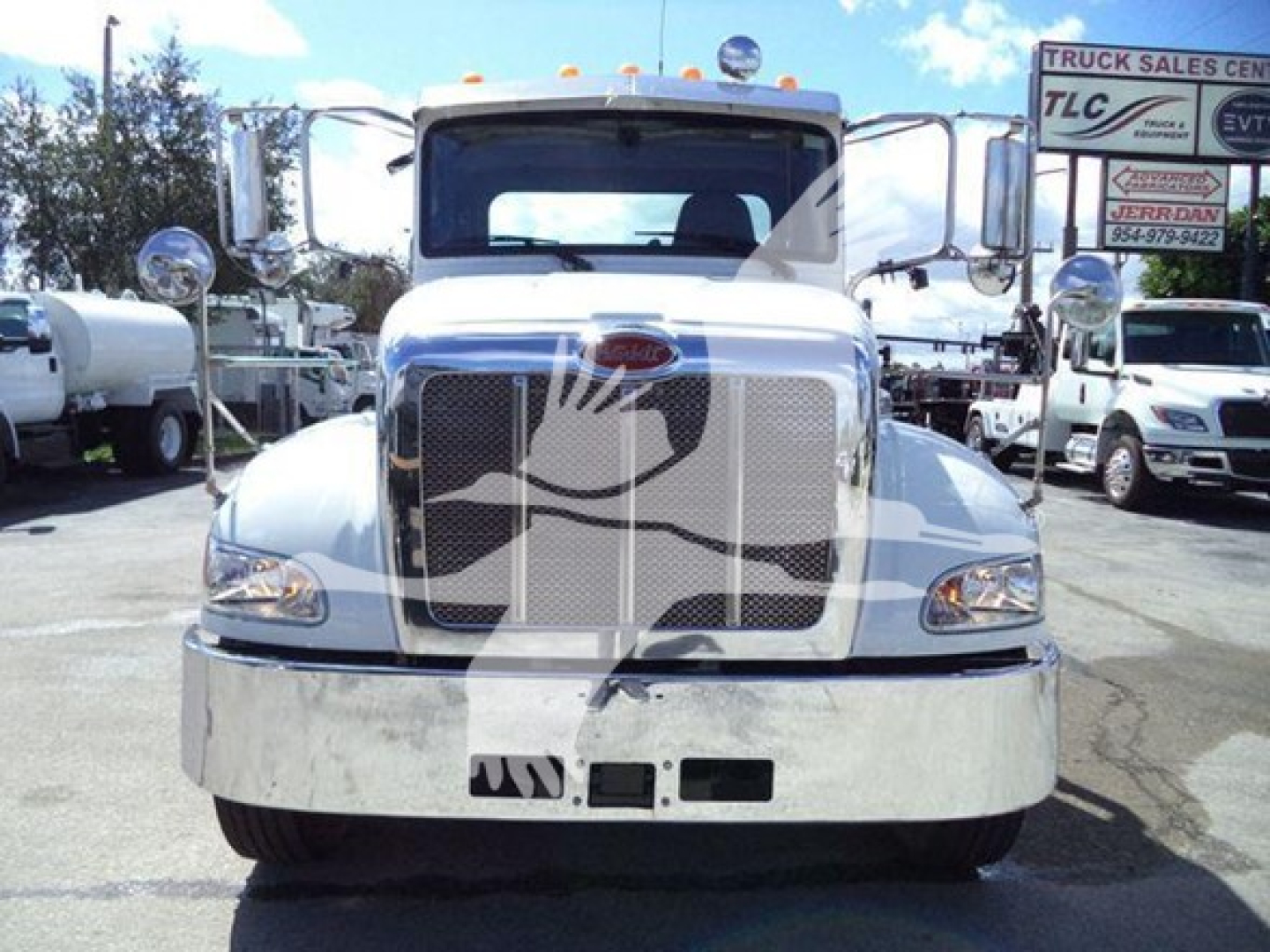 Peterbilt 337 rollback truck front view with chrome grille and headlights, used vehicle in a dealership lot.