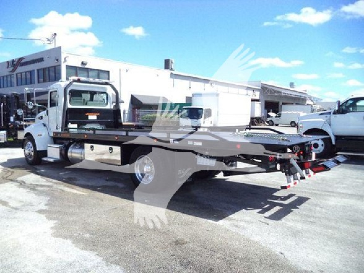 Peterbilt 337 rollback tow truck side view showing low-profile flatbed with winch and hydraulic components.