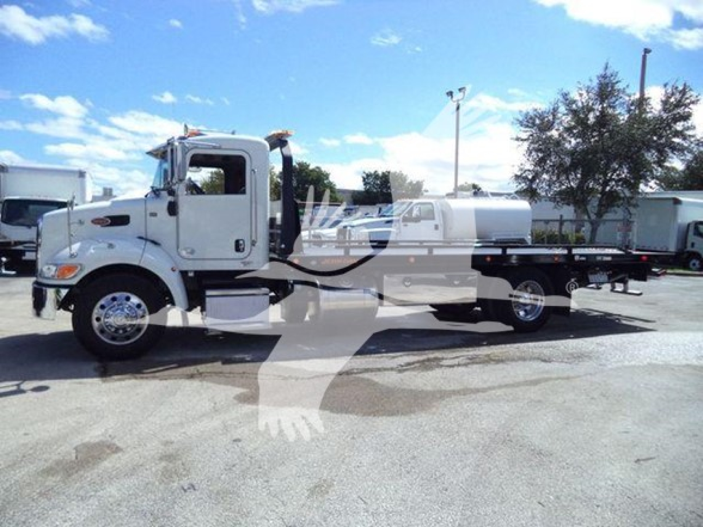 Peterbilt 337 rollback truck side view showing cab and flatbed with chrome wheels and white paint.