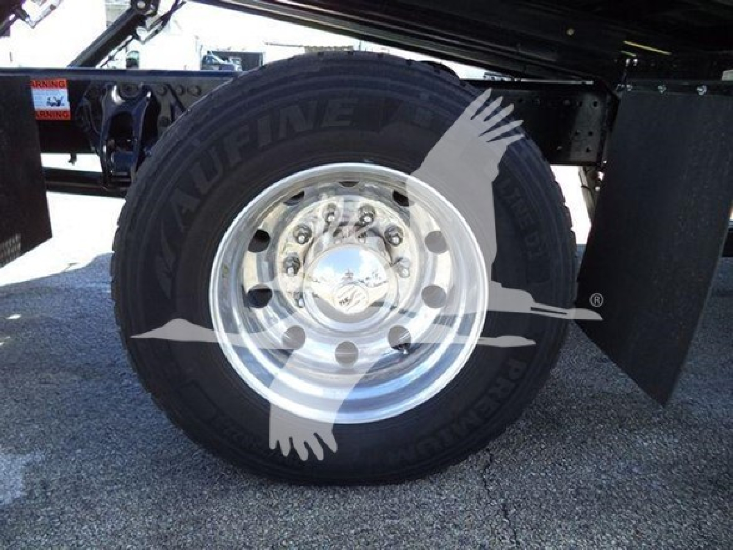Peterbilt 337 rollback truck wheel and tire, shiny chrome hub, black tire with raised letters, undercarriage frame visible