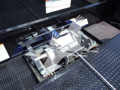 Truck component bay showing winch and hydraulic reels mounted on a metal diamond plate surface.