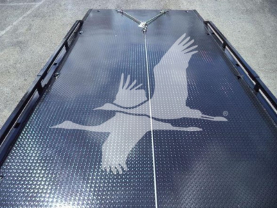 Peterbilt 337 rollback truck bed with diamond plate surface and bird graphic seen from rear, showing long dual rails and tiedown points.