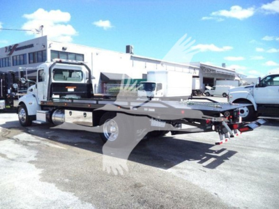 Peterbilt 337 rollback tow truck side view showing low-profile flatbed with winch and hydraulic components.