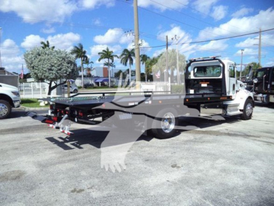 Tow truck with rollback flatbed and cab in view, Peterbilt 337, side profile, chrome wheels, rear towing apparatus extended.