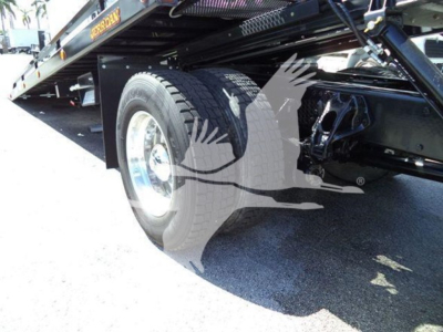 Peterbilt 337 rollback truck wheel and undercarriage showing rear wheel, frame, and hydraulic lines.