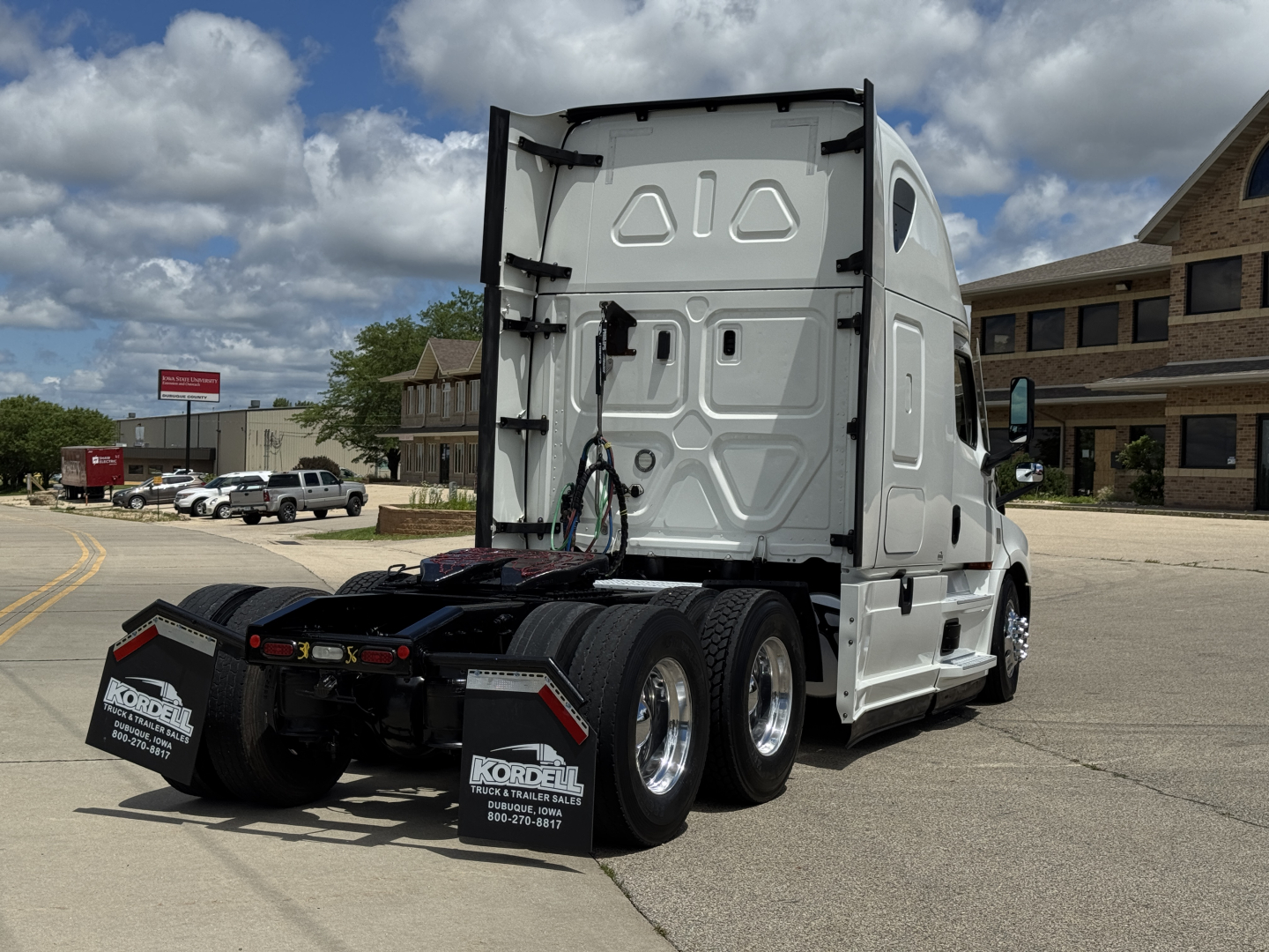 Freightliner Cascadia 126 tractor rear view showing fifth wheel and dual rear axles with chrome wheels.